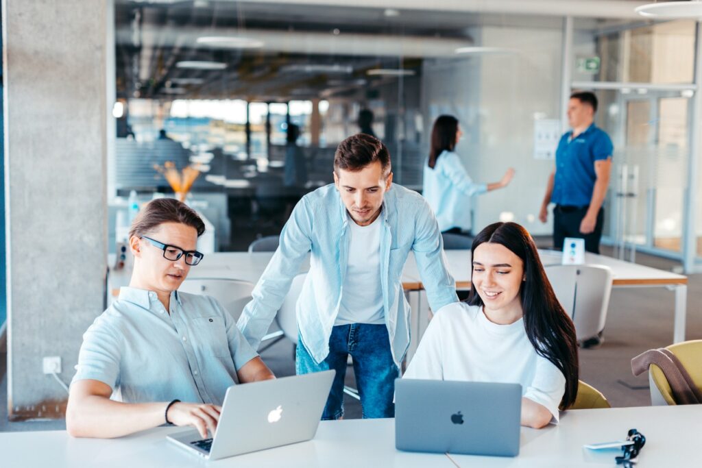 Kleines Team arbeitet gemeinsam an Laptops